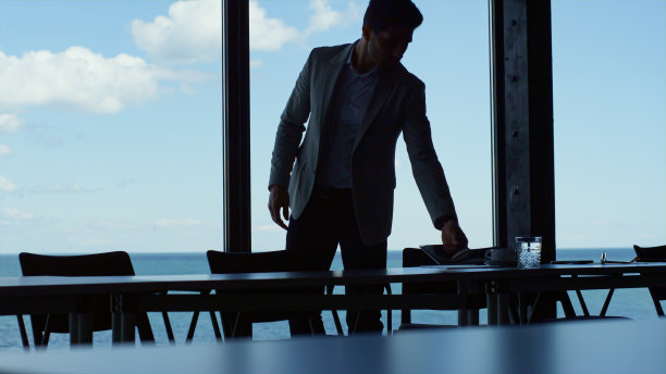 专注的经理使用平板电脑在现代海景办公室。人抱垫图片下载