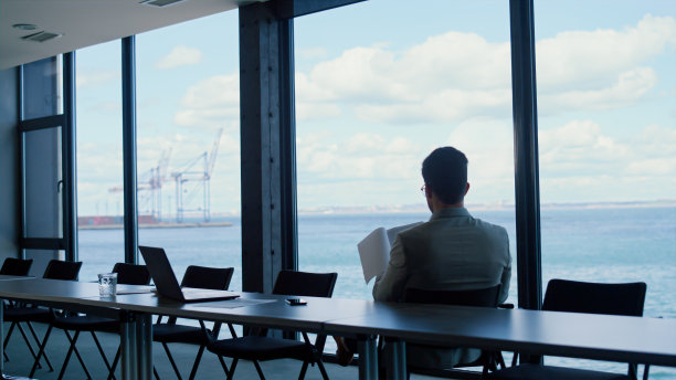 领导在全景窗口看报纸。分析交易概念图片下载