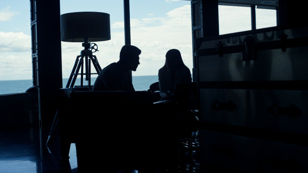 商务人士剪影谈黄昏办公室工作场所。夫妻调情图片下载