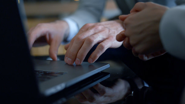 特写搭档的手在办公室工作的笔记本电脑。同事打字键盘图片下载