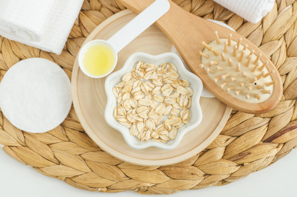 装有燕麦片和木梳子的小碗。自制发膜或面膜，天然美容和水疗配方。俯视图，复制空间。图片下载