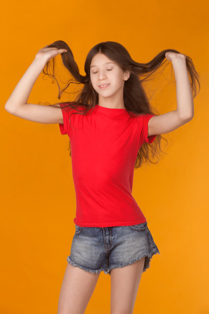 年轻的女孩笑着闭着眼睛，快乐的表情跳舞，抱着头发图片下载