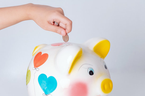 女人用手往存钱罐里扔硬币图片下载