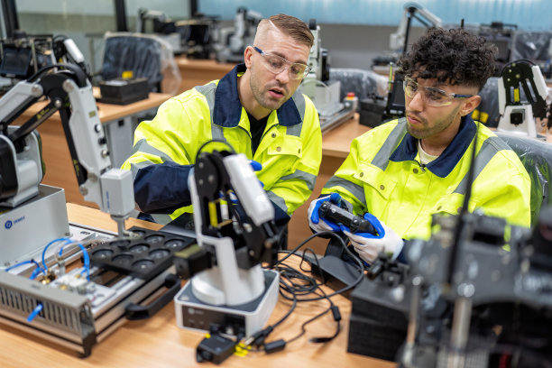 工程师在培训室教学员如何操作、维护和编程机械臂图片下载