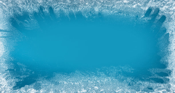 冰冻的窗户上的霜冻图案是圣诞奇观的象征。在窗口的中间是一个模糊的空间，用来放置你的产品或文字。圣诞节或新年背景。图片下载