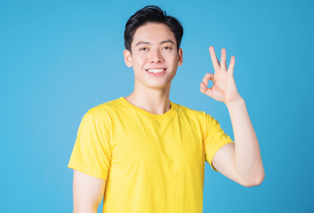 年轻的亚洲人的形象与黄色t恤的背景图片下载