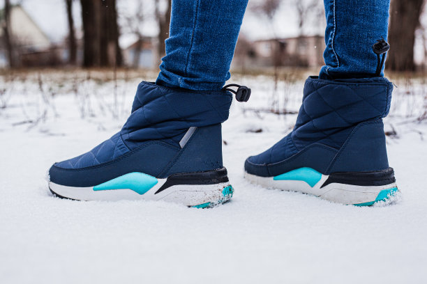 冬季蓬松靴穿在女性腿上，冬季上雪地图片下载