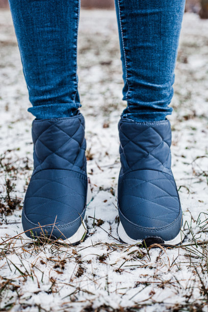 冬季蓬松靴穿在女性腿上，冬季上雪地图片下载