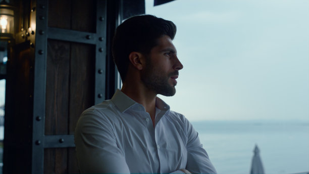 深思熟虑的男人在酒廊餐厅独自看全景海景图片下载