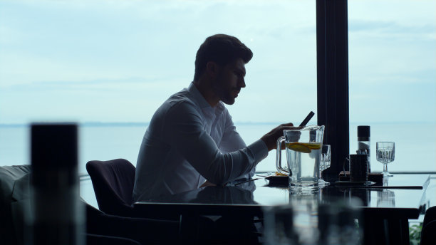 专注的经理在午餐时间在酒店吧台用智能手机上网图片下载
