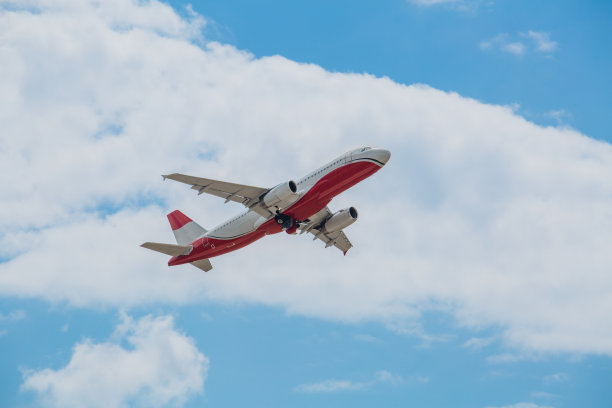 白红色客机在蓝天白云中飞行，空中运输概念，人口疏散图片下载