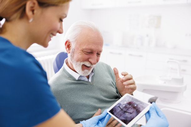 高级男子在牙科诊所咨询牙医图片下载