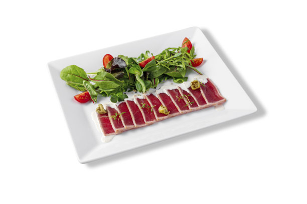 金枪鱼片配酱汁、罗勒、绿豆沙拉、芝麻菜、西红柿、酸豆和豌豆芽放在盘子里，配上白色的背景图片下载