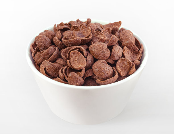 巧克力麦片放在白色的碗里。巧克力味玉米片。小麦。可可。脆皮。脆脆的。早餐。零食。麦片。燕麦。图片下载