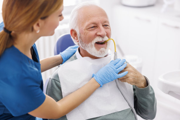 牙医办公室，一名年长男子手持吸口水管图片下载