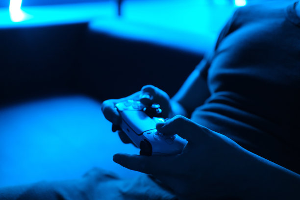 年轻人在玩霓虹灯蓝色的游戏机图片下载