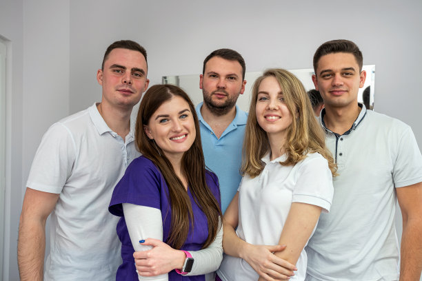 五位精力充沛的医学专家对着病人微笑。图片下载