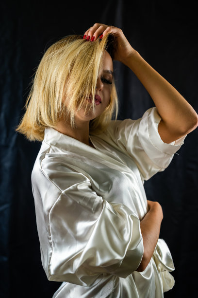 性感优雅的性感女孩在诱人的睡衣摆姿势在一个简单的黑暗背景。图片下载