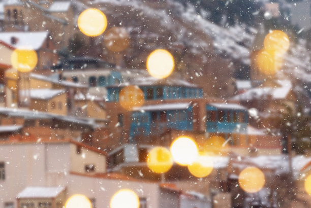 第比利斯市美丽的冬季模糊背景与飘落的雪和散景灯图片下载