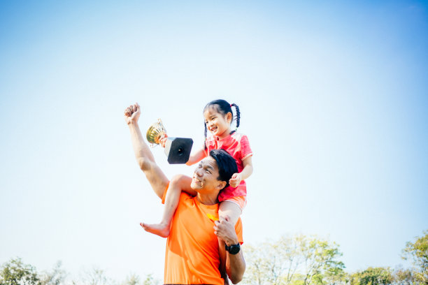 父女俩手捧奖杯庆祝图片下载