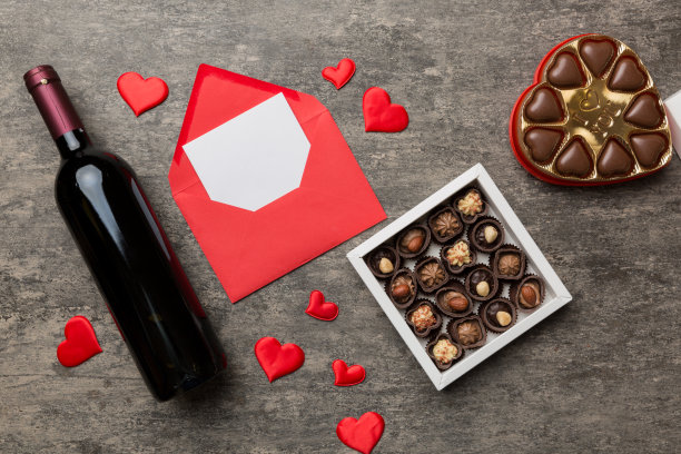 情人节彩色背景红酒，礼盒，信封和巧克力。心形的礼盒巧克力顶部视图与复制空间图片下载