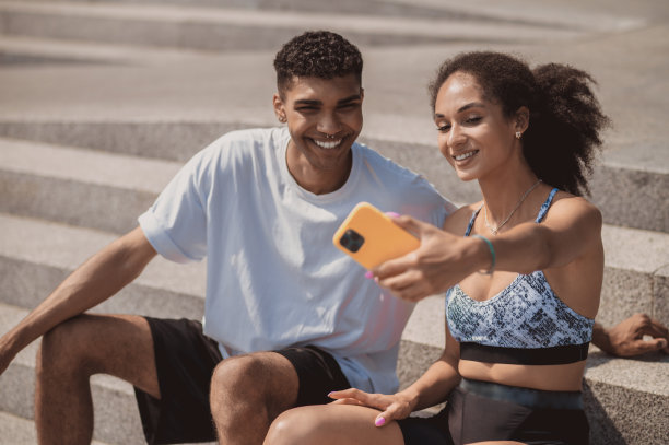 一对运动情侣坐在台阶上自拍图片下载