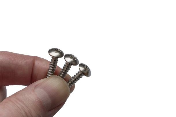三个白色自攻螺钉在手上隔离图片下载