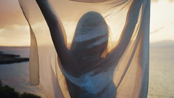 美丽神秘的女人，金色的长发，透明的白色面纱在风中摇曳图片下载