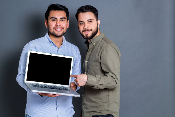 年轻的工作人员指着笔记本电脑屏幕图片下载