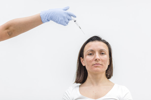 皮肤干燥的女性特写照片，手上戴着注射用的医用手套。图片下载