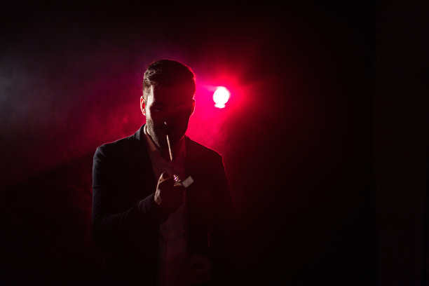 粉红色背景上吸烟男子的照片。图片下载