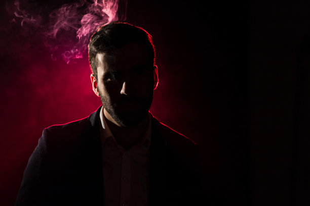 粉红色背景上吸烟男子的照片。图片下载