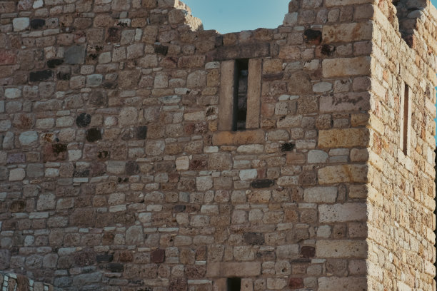 一座中世纪旧城堡的石墙，背后是晴朗的天空图片下载