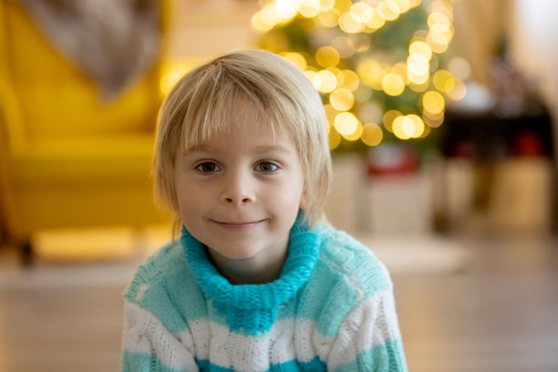 可爱的孩子，孩子，坐在装饰房间的黄色扶手椅上过圣诞节图片下载