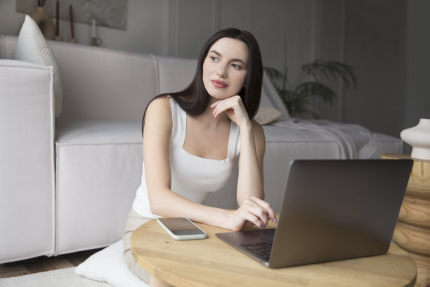 在度假屋工作，远程工作者。在任何地方工作。女性自由职业者从家里连接到互联网。可爱的年轻女子在时尚的客厅里使用笔记本电脑。图片下载