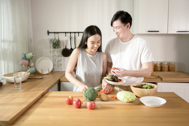 一对亚洲年轻夫妇喜欢在家里的厨房里用健康的蔬菜和水果食材烹饪，健康健康的生活理念。图片下载
