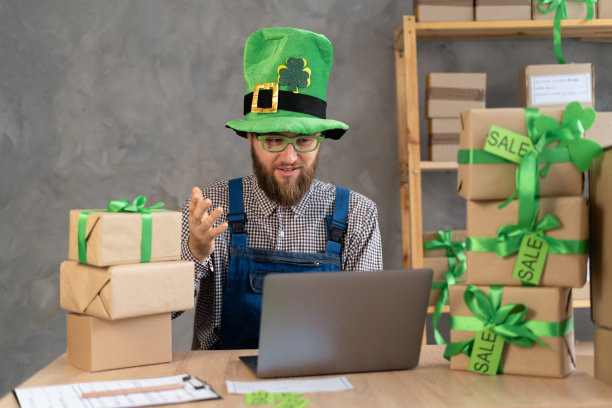 开始小生意的老板，卖家准备包裹盒子，用电脑送货给客户。网上销售，圣帕特里克节销售，商业，航运图片下载