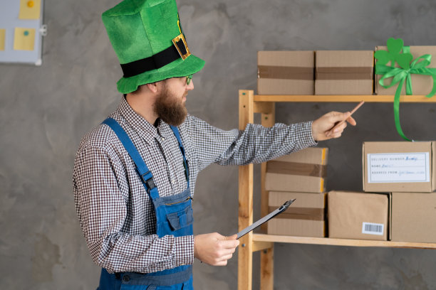 刚起步的小企业主在工作时检查包裹，销售人员检查生产订单。圣帕特里克节大减价。销售电子商务运输理念图片下载