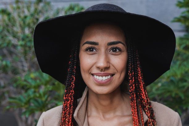 年轻的非洲妇女戴着时髦的帽子在城市在冬天的时候图片下载