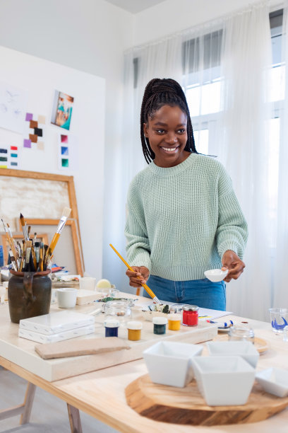 年轻的女艺术家在她的画室里图片下载