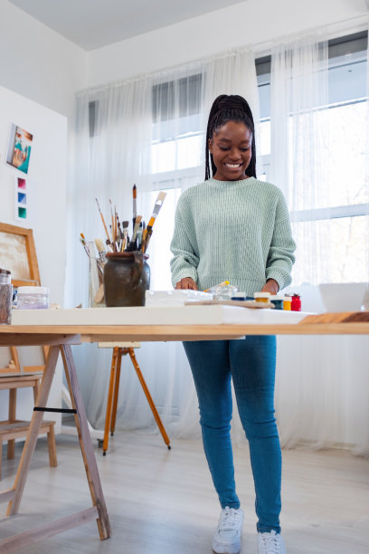 年轻的女艺术家在她的画室里图片下载