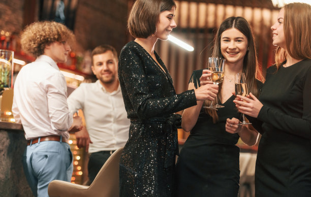 的乐趣。一群人穿着漂亮优雅的衣服一起在室内庆祝新年图片下载