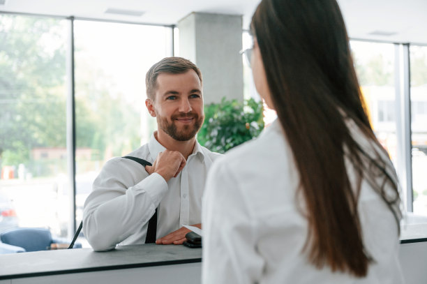 友好的客户。穿白衬衫的男子在一名女子的帮助下在旅馆订房间图片下载