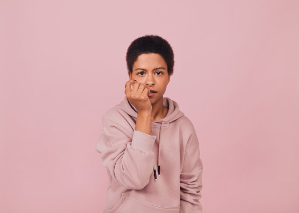 不确定的困惑黑人女孩咬她的指甲。图片下载