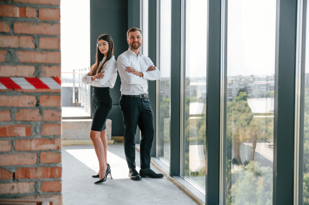 靠近大的全景窗。工业工人白天在大楼里工作。建设地点图片下载