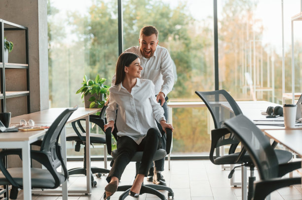 休息时间。的乐趣。坐椅子。男人和女人一起在现代化的办公室里工作图片下载