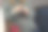 不知名的白种人孕妇针织坐在椅子上，寒冷的季节妇女穿着温暖的羊毛衣服，毛衣和蓝色牛仔裤。红色的纱线球，线放在桌子上。高质量照片图片下载