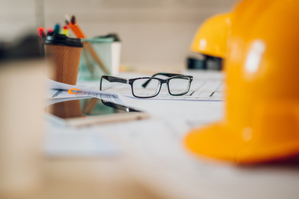 头盔、蓝图和设备放在建筑师或工程师的桌子上图片下载