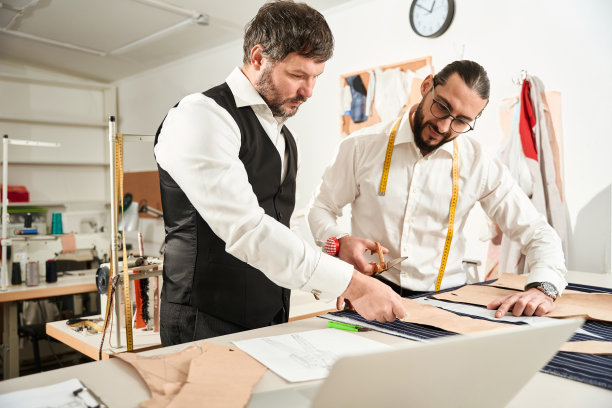 制衣工人准备裁剪男式西装的布料图片下载