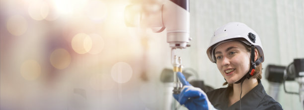 女工程师在制造自动化和机器人技术学院的房间里控制自主移动机器人。女性工程师培训或维护人工智能机器人图片下载